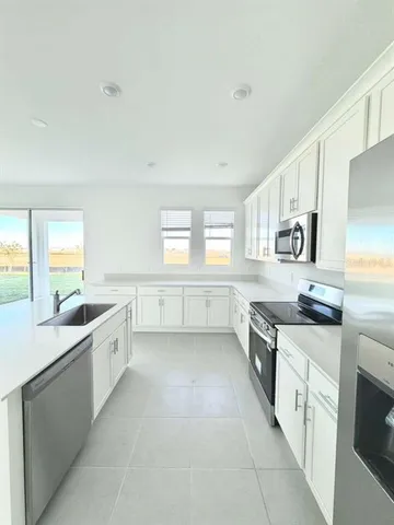 a large kitchen with a stove top oven sink and cabinets