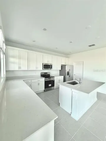 a large white kitchen with cabinets and a sink