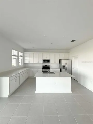 a living room with furniture a flat screen tv and a window