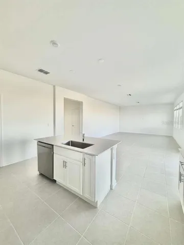 a kitchen with stainless steel appliances a stove a sink and white cabinets