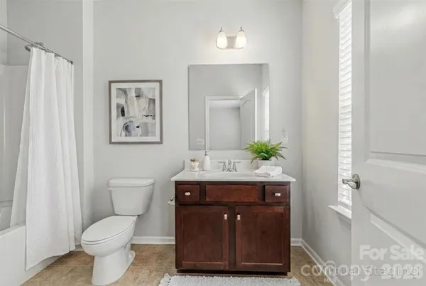 a bathroom with a sink a toilet and shower curtain
