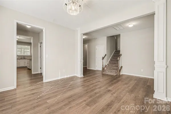 an empty room with wooden floor and mirror