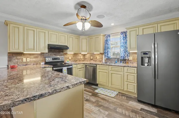 a kitchen with a refrigerator a sink dishwasher with a dining table and chairs