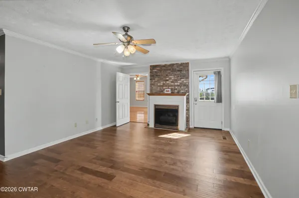 a view of an empty room with a fireplace and a window
