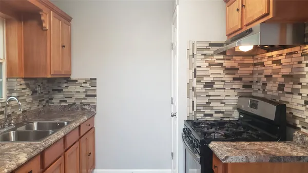 a kitchen with granite countertop a stove and a sink