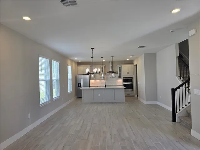 a large kitchen with kitchen island a large counter space a sink stainless steel appliances and cabinets