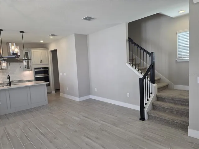 a view of a kitchen with wooden floor and electronic appliances