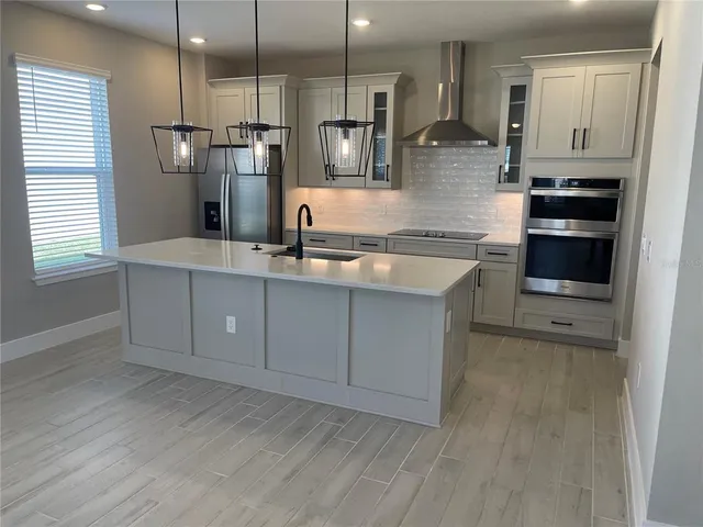 a kitchen with stainless steel appliances granite countertop a refrigerator a stove and a sink