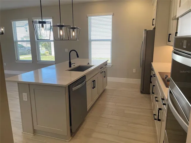 a kitchen with stainless steel appliances a sink stove and refrigerator