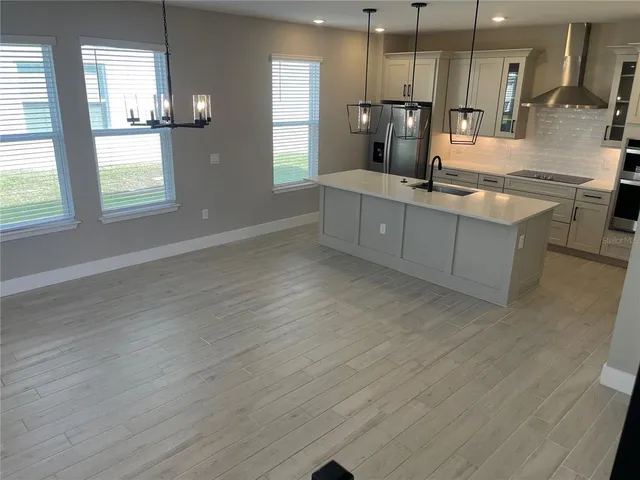 a kitchen with kitchen island granite countertop a sink cabinets and stainless steel appliances
