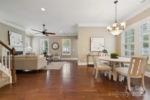 a living room with furniture a chandelier and a dining table