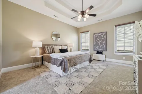 a bedroom with a large bed and a chandelier