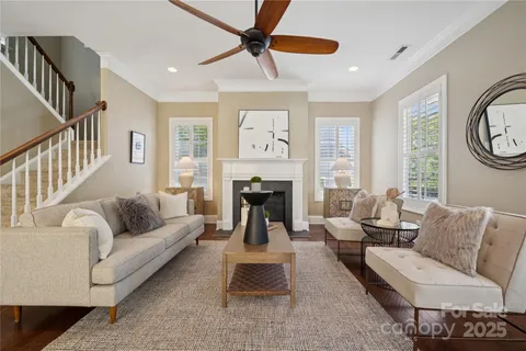 a living room with furniture two window and a fireplace