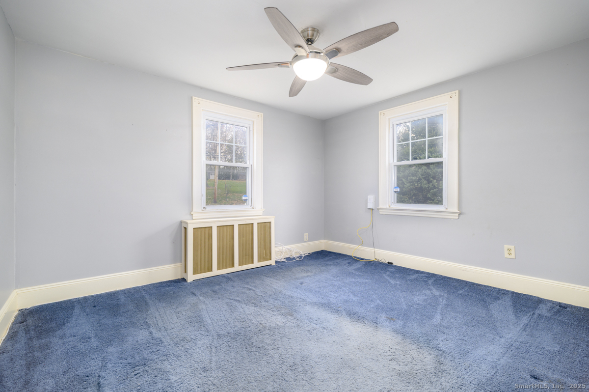 279 Knapps Highway Fairfield, CT 06825 - Photo 12 of 24 an empty room with windows and ceiling fan