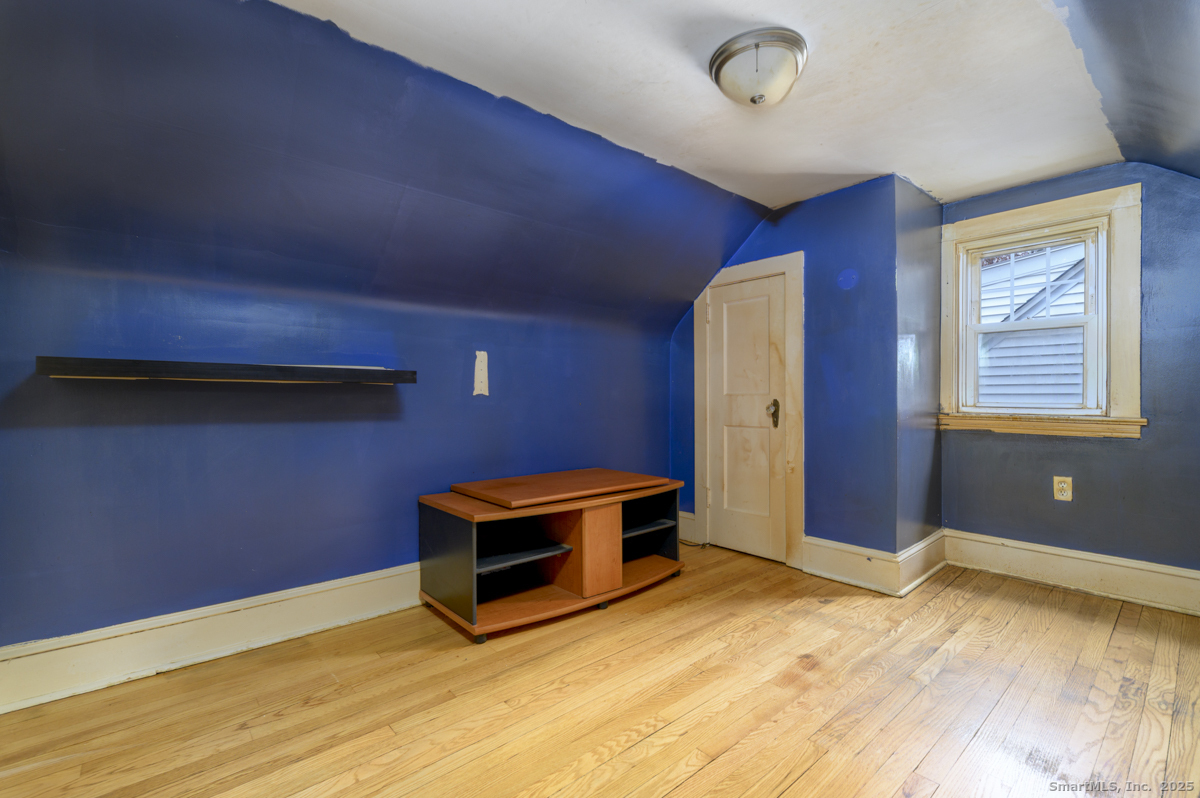 279 Knapps Highway Fairfield, CT 06825 - Photo 18 of 24 a view of a livingroom with wooden floor and a ceiling fan