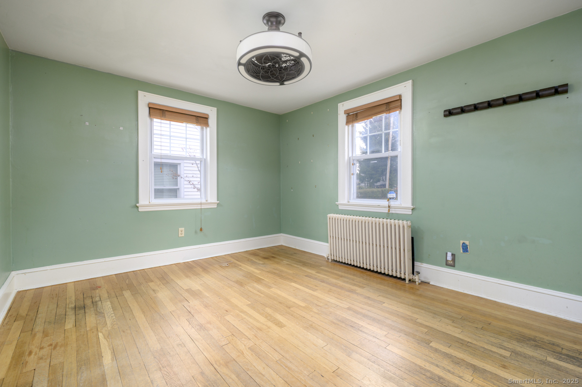 279 Knapps Highway Fairfield, CT 06825 - Photo 3 of 24 a view of an empty room with a window and wooden floor