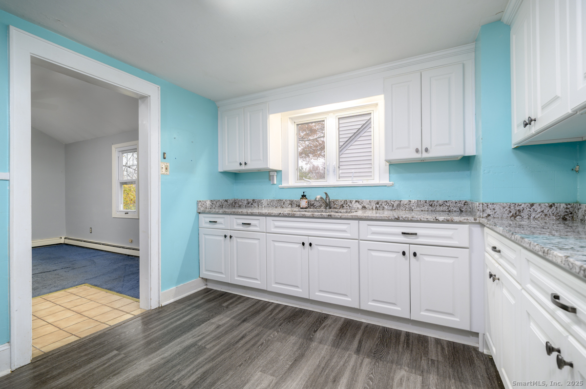 279 Knapps Highway Fairfield, CT 06825 - Photo 5 of 24 a kitchen with granite countertop white cabinets and white appliances