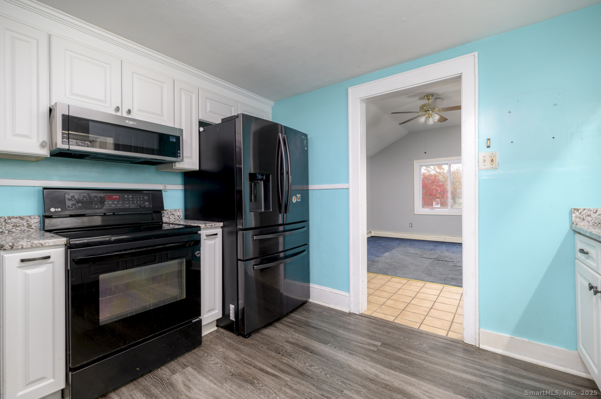 279 Knapps Highway Fairfield, CT 06825 - Photo 6 of 24 a kitchen with stainless steel appliances wooden floor sink and wooden cabinets