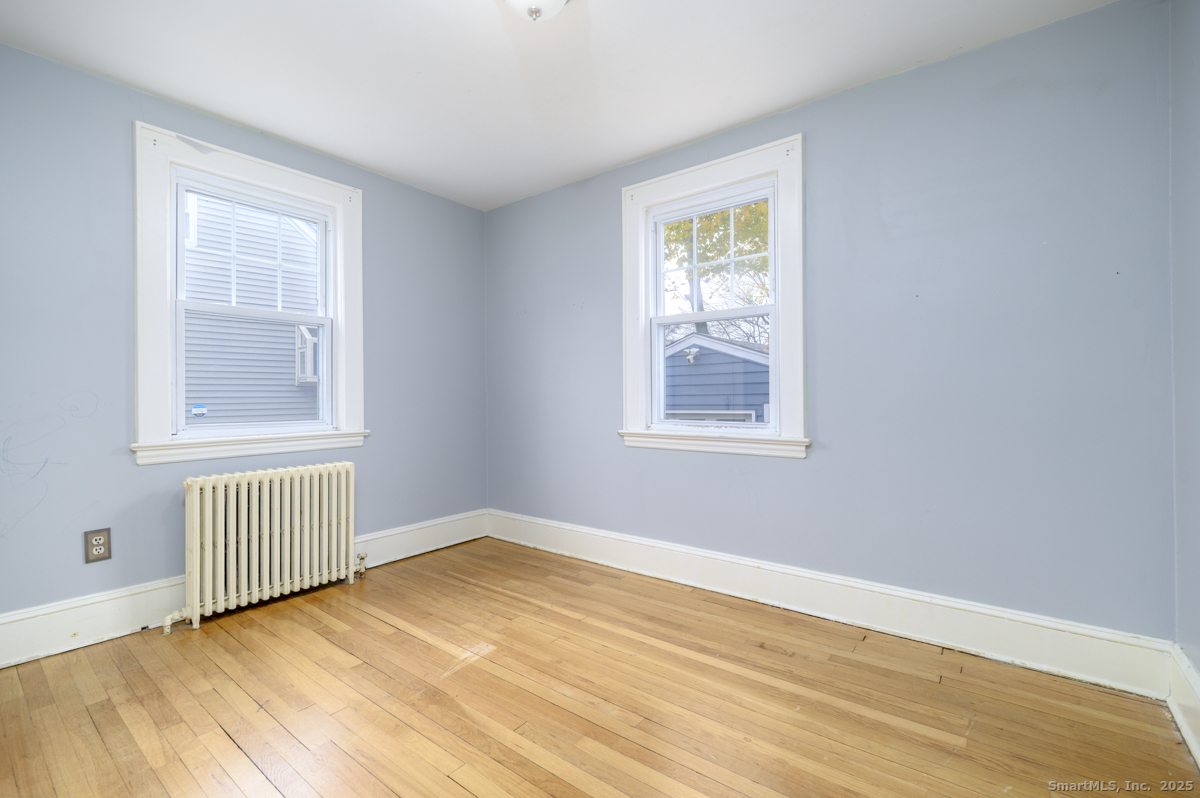 279 Knapps Highway Fairfield, CT 06825 - Photo 10 of 24 a view of an empty room with wooden floor and a window