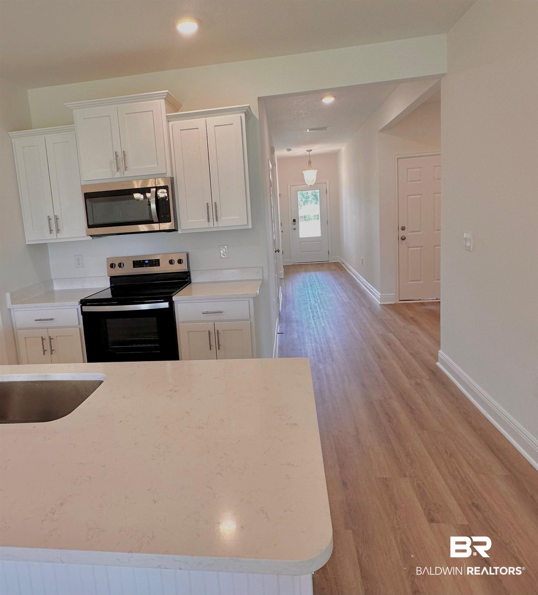 12877 Grand Rpds Road Fairhope, AL 36532 - Photo 2 of 31 Kitchen featuring appliances with stainless steel finishes, white cabinets, and light hardwood / wood-style floors