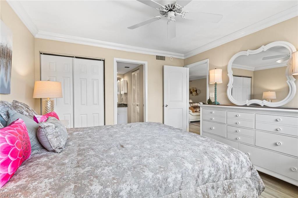 1004 Manatee Road, Unit H306 Naples, FL 34114 - Photo 18 of 48 a bedroom with a large bed and a mirror on dresser