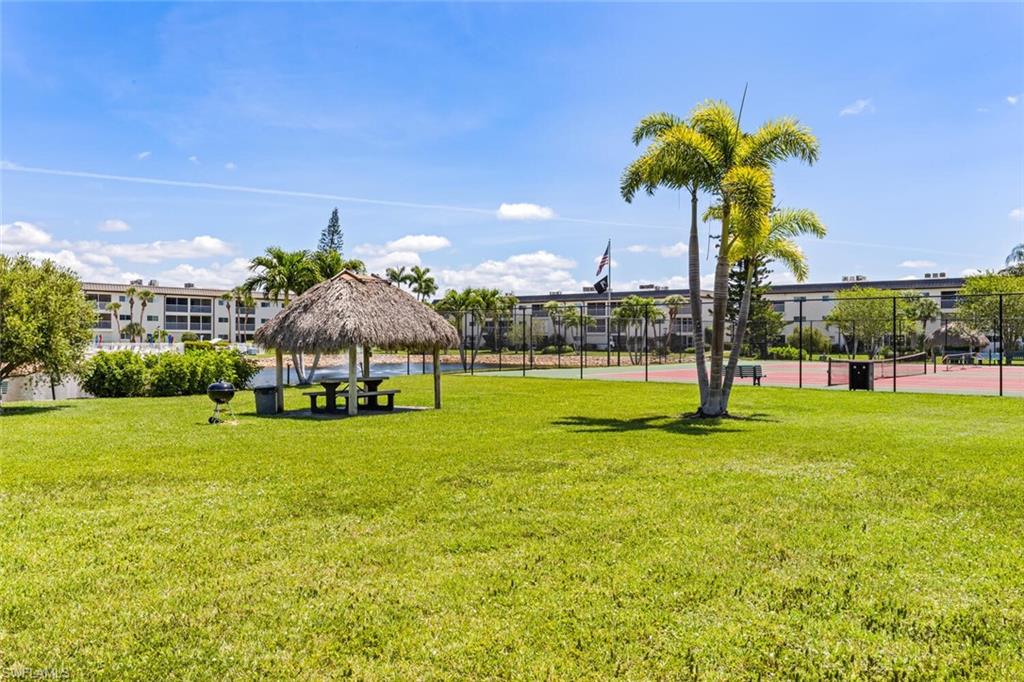 1004 Manatee Road, Unit H306 Naples, FL 34114 - Photo 44 of 48 a front view of a house with a yard and palm trees