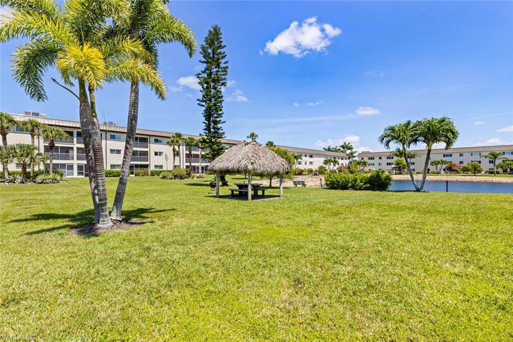 1004 Manatee Road, Unit H306 Naples, FL 34114 - Photo 45 of 48 a yellow swimming pool is in the garden of a house