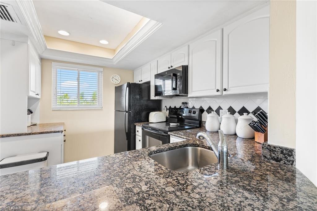 1004 Manatee Road, Unit H306 Naples, FL 34114 - Photo 9 of 48 a kitchen with a sink stove and cabinets