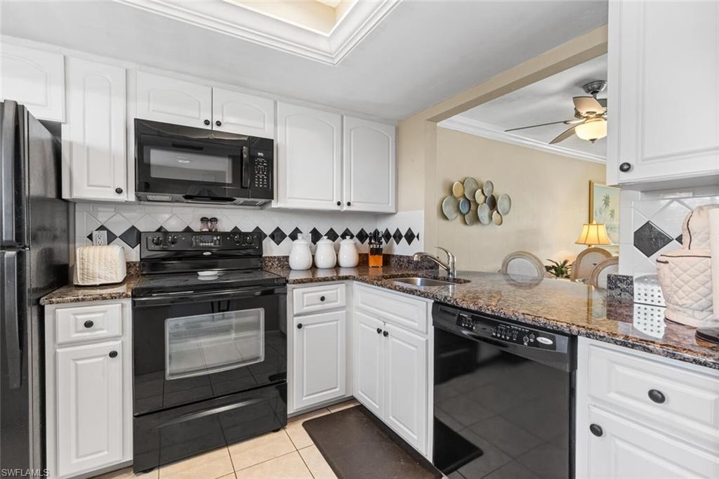 1004 Manatee Road, Unit H306 Naples, FL 34114 - Photo 10 of 48 a kitchen with stainless steel appliances granite countertop a stove a sink and a microwave