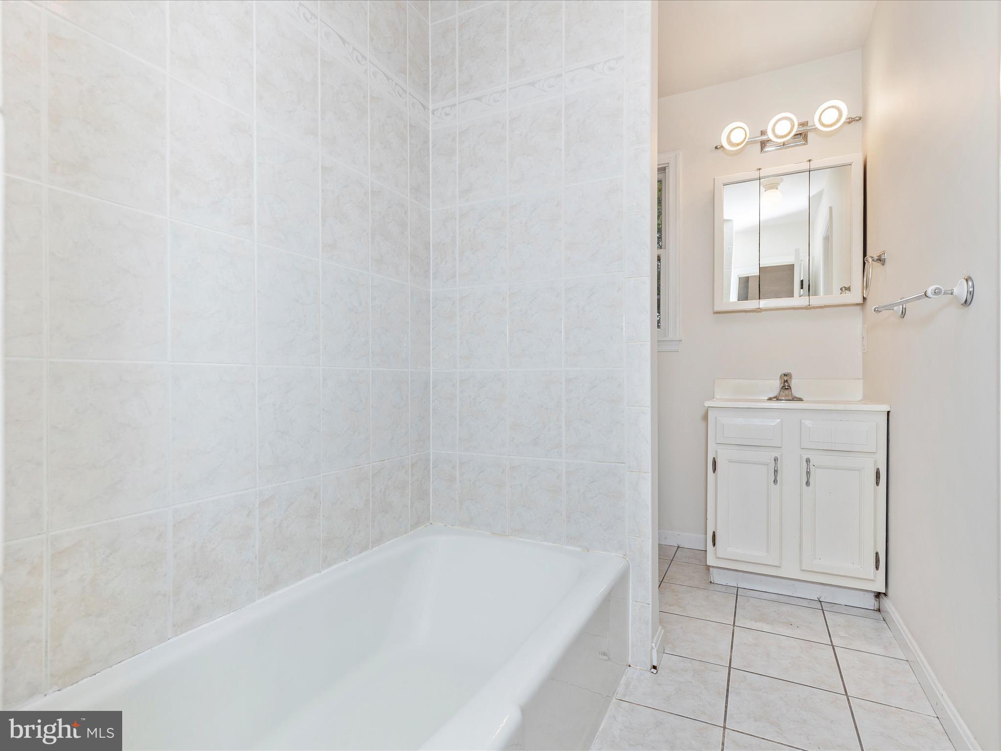 402 Windy Knoll Drive Mount Airy, MD 21771 - Photo 30 of 51 a bathroom with a bathtub a sink a vanity and a mirror