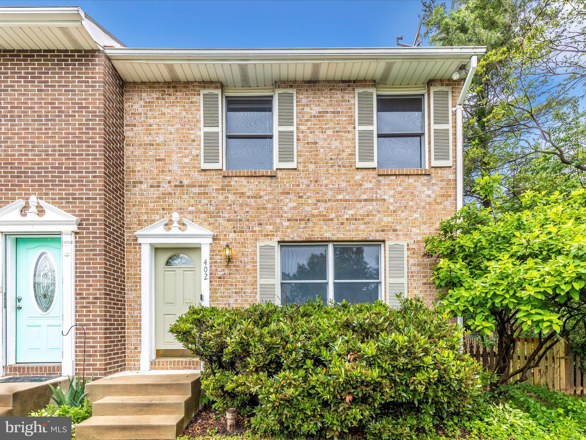 402 Windy Knoll Drive Mount Airy, MD 21771 - Photo 50 of 51 a view of a brick house with a small yard and large tree