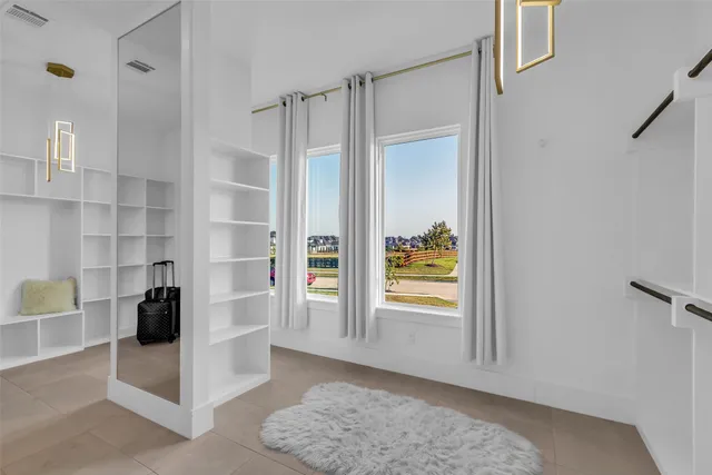 a view of walk in closet with clothes and shoes