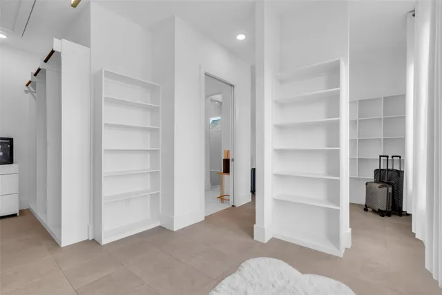 a view of an empty room with closet and a window