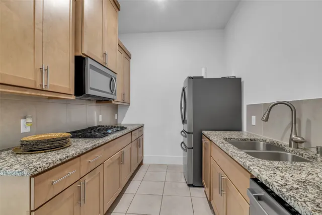 a kitchen with stainless steel appliances granite countertop a sink stove and refrigerator