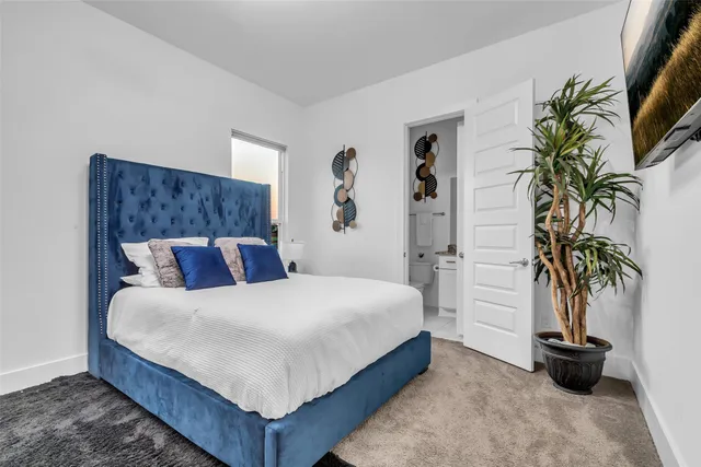 a bedroom with a bed and potted plant