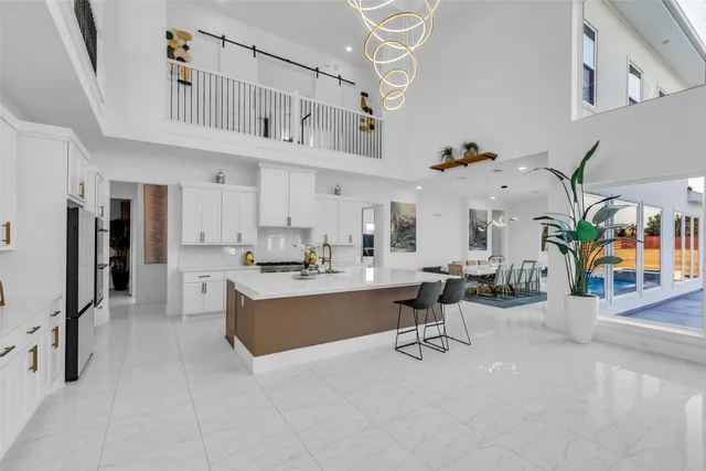 a living room with furniture a flat screen tv and a refrigerator