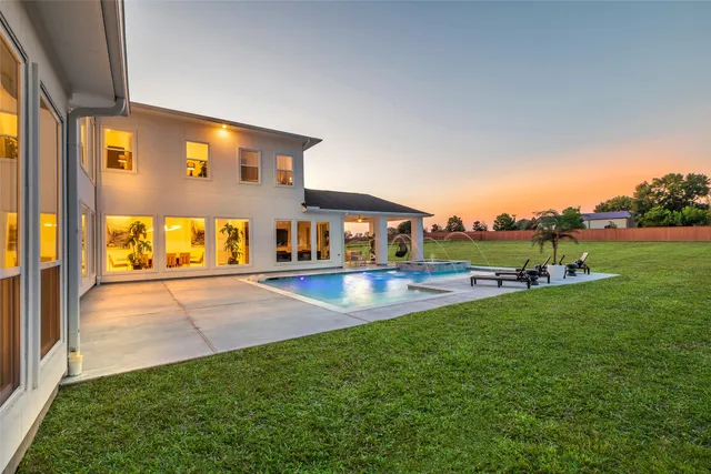 a view of an house with backyard space and balcony