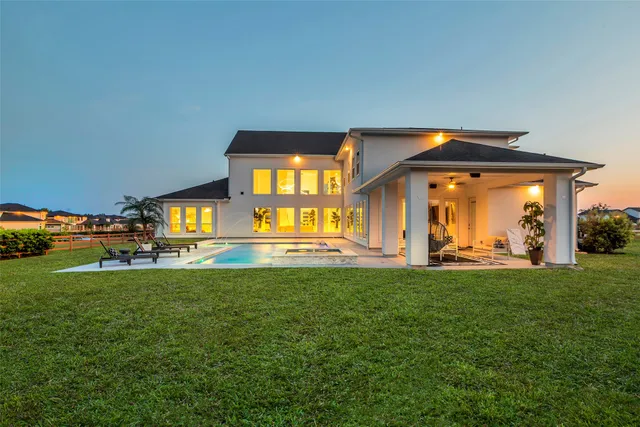 a view of a house with a big yard and a large parking space
