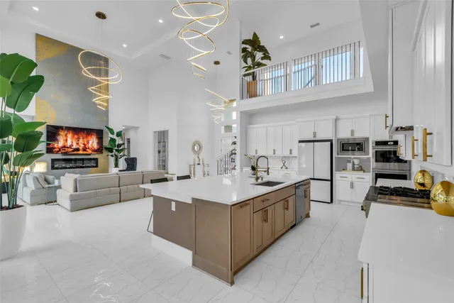 a living room with stainless steel appliances furniture and a flat screen tv
