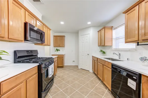 a kitchen with stainless steel appliances a stove sink microwave and cabinets