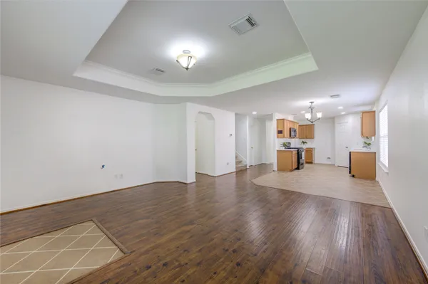 a view of an empty room with wooden floor