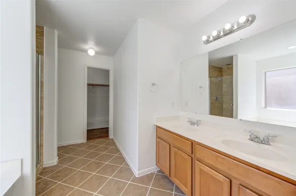 a spacious bathroom with a sink a mirror and a shower