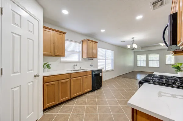 a large kitchen with stainless steel appliances a stove sink and cabinets