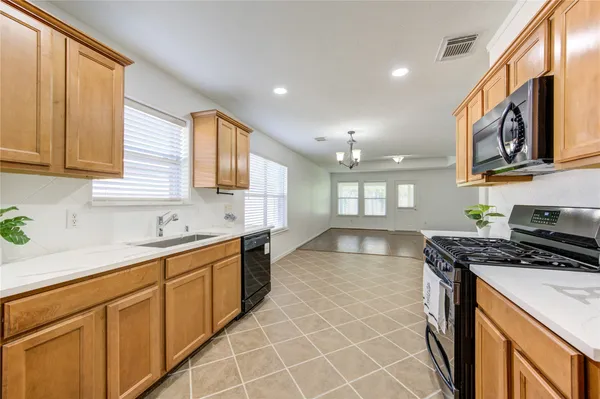 a kitchen with stainless steel appliances granite countertop a stove a sink and a microwave