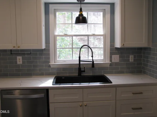 a metallic refrigerator freezer sitting in a kitchen