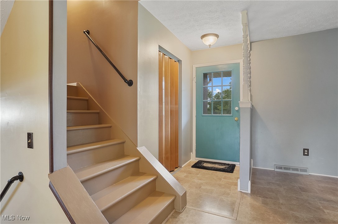 3262 Wright Road Northwest Uniontown, OH 44685 - Photo 11 of 37 Entryway with stairs and a textured ceiling