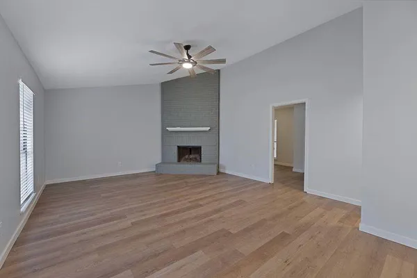 a view of empty room with wooden floor and fireplace