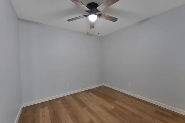 a view of empty room with wooden floor