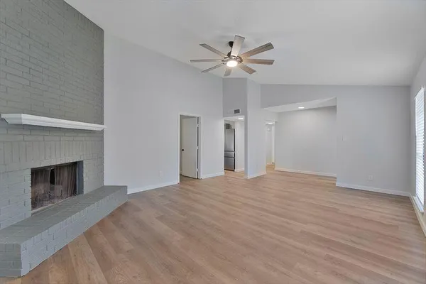 a view of empty room with wooden floor and fireplace