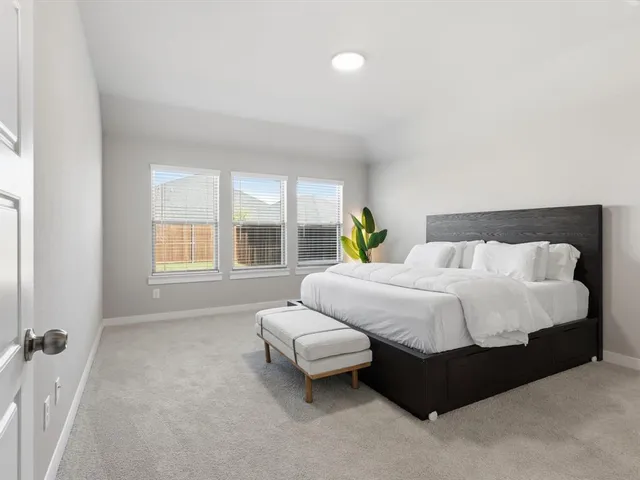 a spacious bedroom with a bed and window